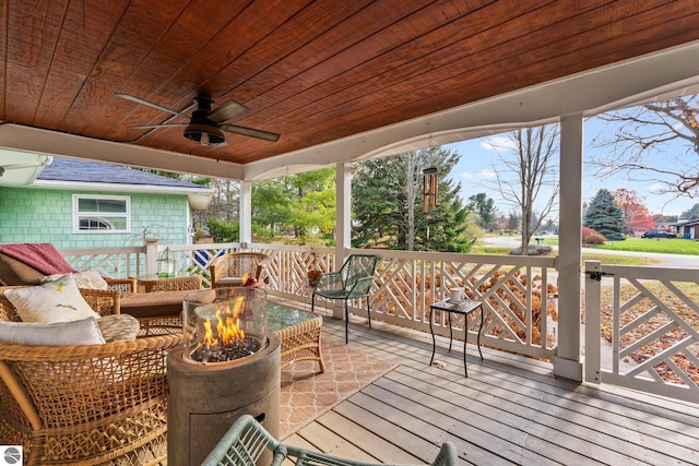 wooden terrace with an outdoor living space with a fire pit and a ceiling fan