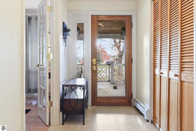 doorway to outside with light tile patterned floors and baseboard heating