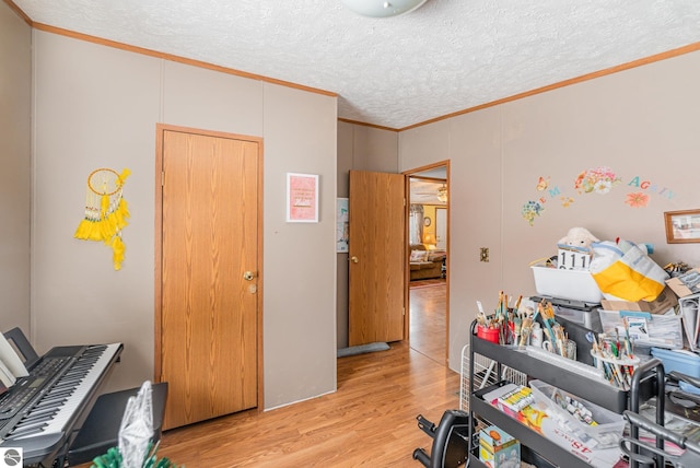 office featuring a textured ceiling, crown molding, and light wood-style floors