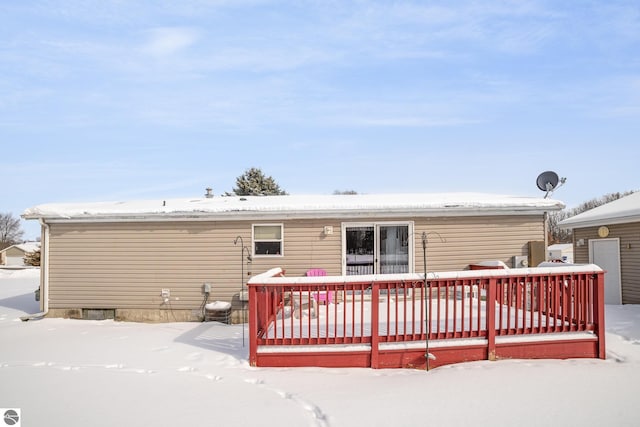 snow covered rear of property featuring a wooden deck