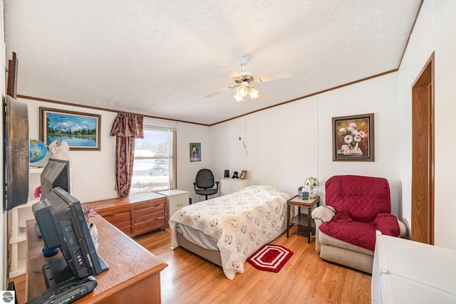 bedroom with light wood-style flooring, a textured ceiling, and crown molding