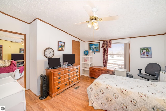 bedroom featuring ceiling fan, vaulted ceiling, ornamental molding, light wood-style flooring, and a textured ceiling