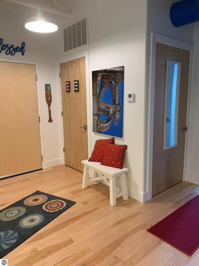 entryway featuring light wood-style flooring, visible vents, and baseboards