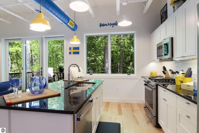 kitchen featuring appliances with stainless steel finishes, plenty of natural light, a sink, and decorative backsplash