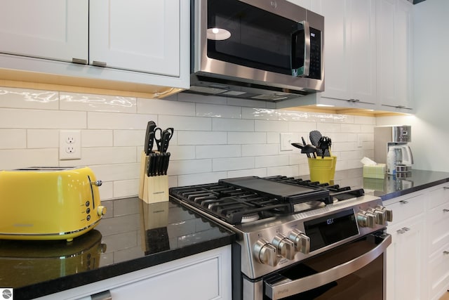 kitchen with tasteful backsplash, a toaster, white cabinets, dark stone counters, and stainless steel appliances