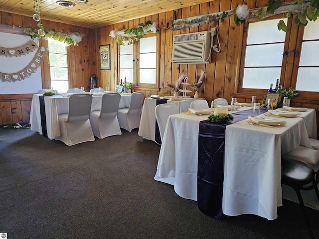 dining space with carpet floors, wooden ceiling, wooden walls, and a wall mounted air conditioner