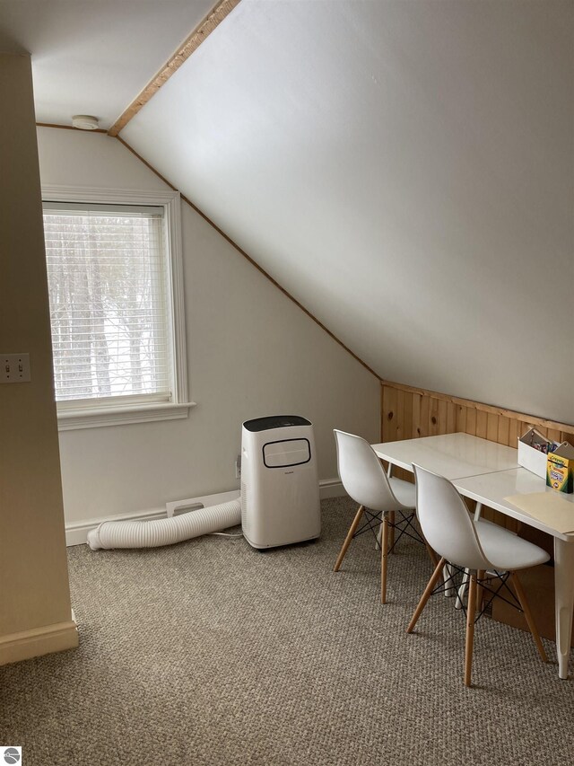 unfurnished office featuring lofted ceiling, carpet, and baseboards