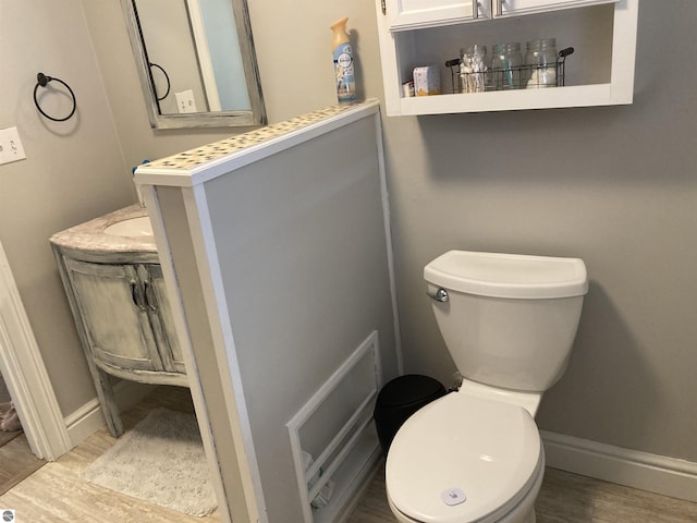 bathroom featuring wood finished floors, toilet, and baseboards