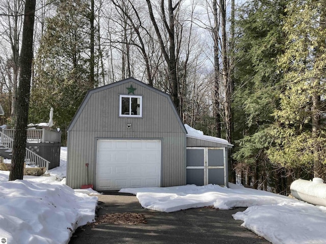 snow covered garage featuring a detached garage