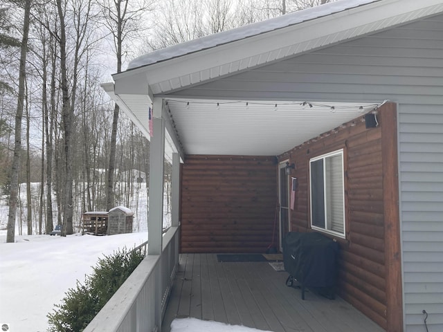 snow covered deck with a grill