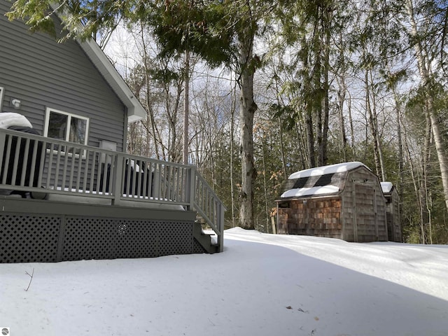 yard covered in snow with an outbuilding and a wooden deck