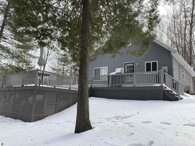 snow covered rear of property featuring a wooden deck