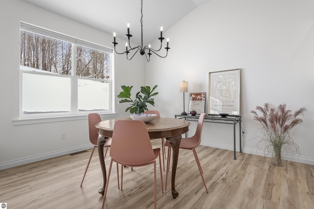 dining room featuring vaulted ceiling, light wood finished floors, visible vents, and baseboards