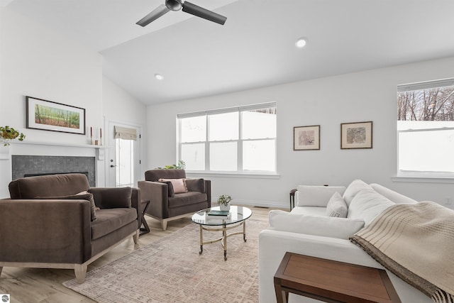 living area with lofted ceiling, ceiling fan, light wood-style floors, a fireplace, and recessed lighting