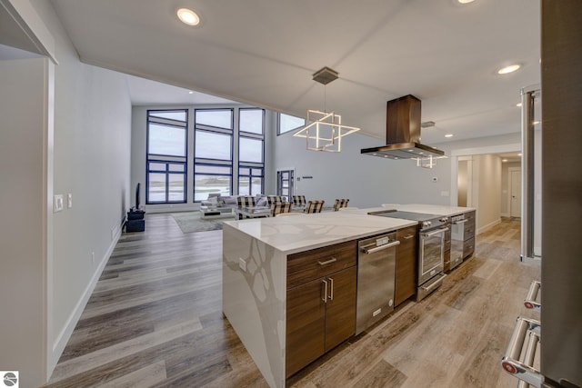 kitchen featuring a kitchen island, light wood-style flooring, appliances with stainless steel finishes, and island exhaust hood