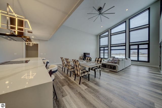 dining area with high vaulted ceiling, wood finished floors, recessed lighting, baseboards, and ceiling fan