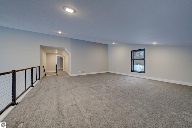 carpeted empty room featuring recessed lighting, visible vents, and baseboards