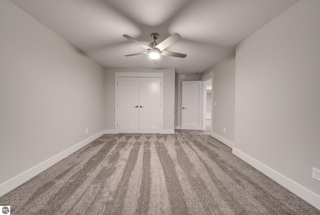 unfurnished bedroom featuring baseboards, carpet floors, a closet, and ceiling fan