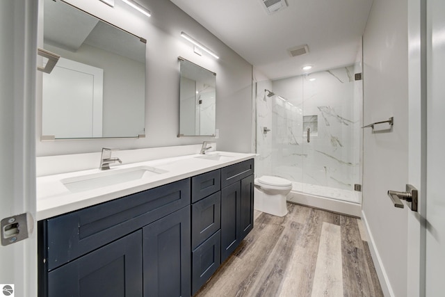 full bath with visible vents, toilet, wood finished floors, and a sink