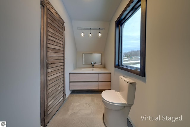 bathroom featuring vanity, toilet, and baseboards