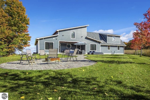 back of property with fence, a lawn, and a patio area