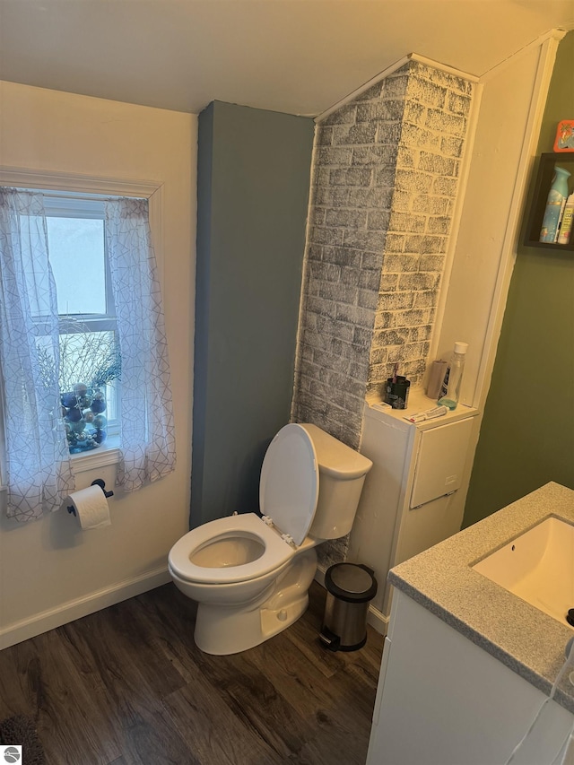 bathroom with toilet, baseboards, wood finished floors, and vanity