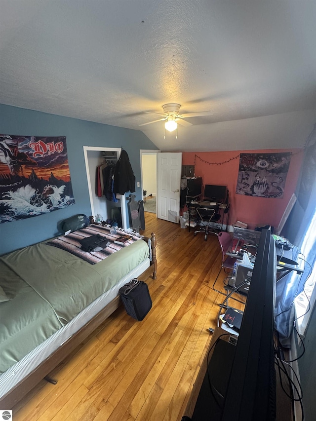 bedroom with wood-type flooring, ceiling fan, and a textured ceiling