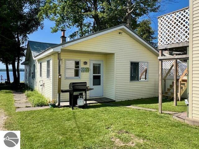 back of property featuring stairs and a lawn