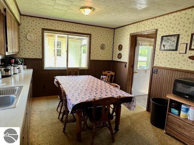 dining room featuring a wainscoted wall and wallpapered walls