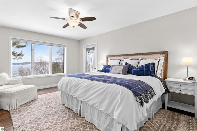 bedroom with multiple windows, baseboards, and wood finished floors