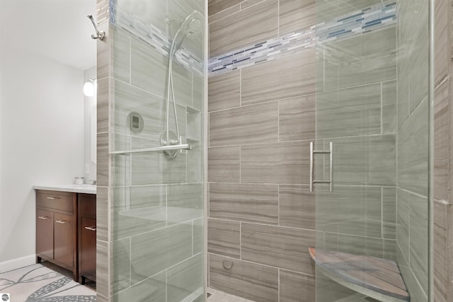 full bath with a shower stall, vanity, and baseboards