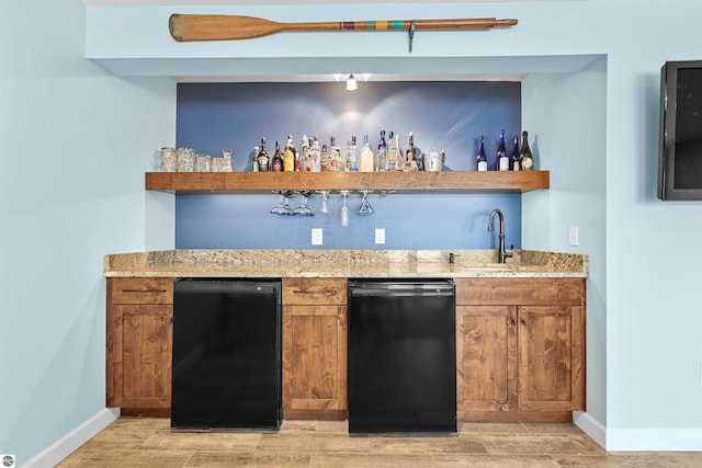 bar featuring a sink, baseboards, wood tiled floor, dishwasher, and indoor wet bar