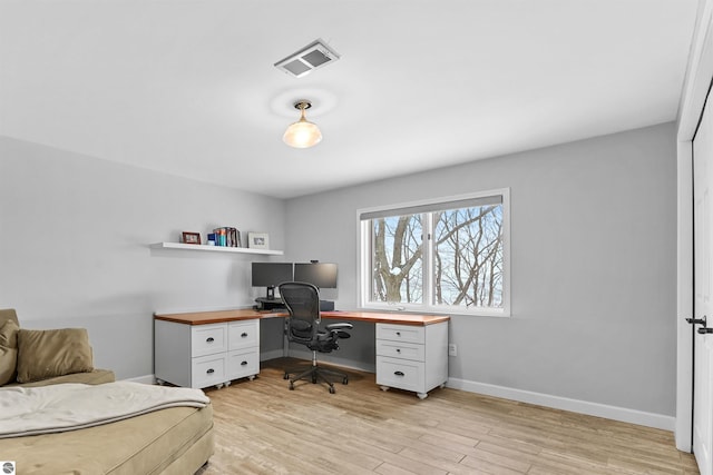 office featuring light wood-style flooring, visible vents, and baseboards