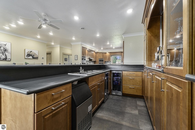 kitchen with dark countertops, ornamental molding, a sink, beverage cooler, and a peninsula