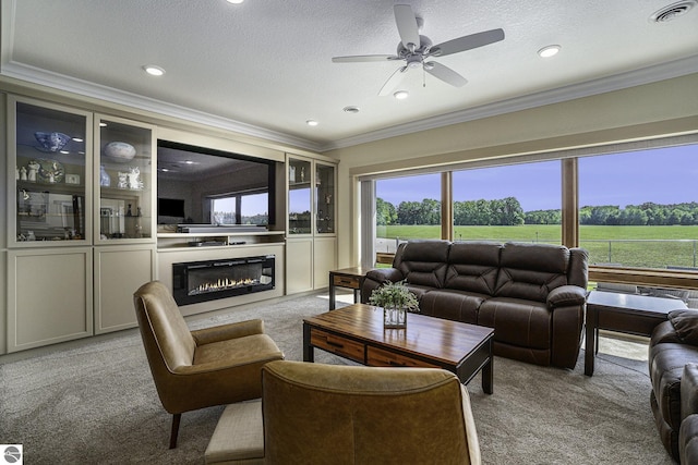 carpeted living area featuring crown molding, visible vents, a ceiling fan, a glass covered fireplace, and a textured ceiling