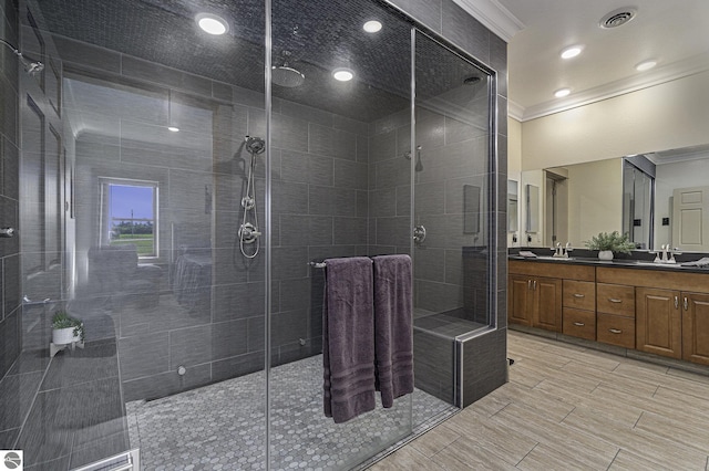 bathroom with double vanity, a stall shower, visible vents, crown molding, and a sink