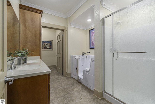 full bathroom with a sink, baseboards, double vanity, a stall shower, and crown molding