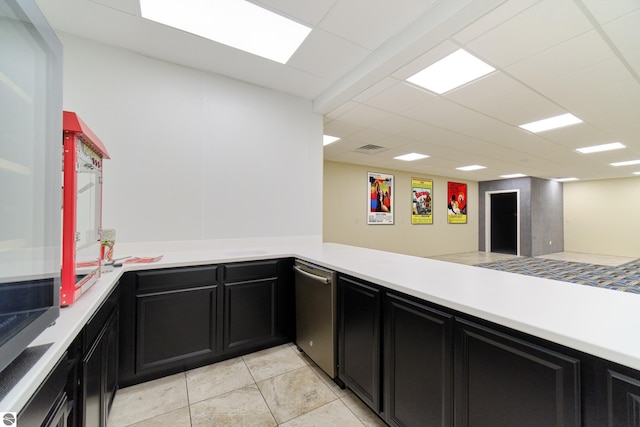 kitchen featuring a paneled ceiling, light countertops, and dark cabinetry