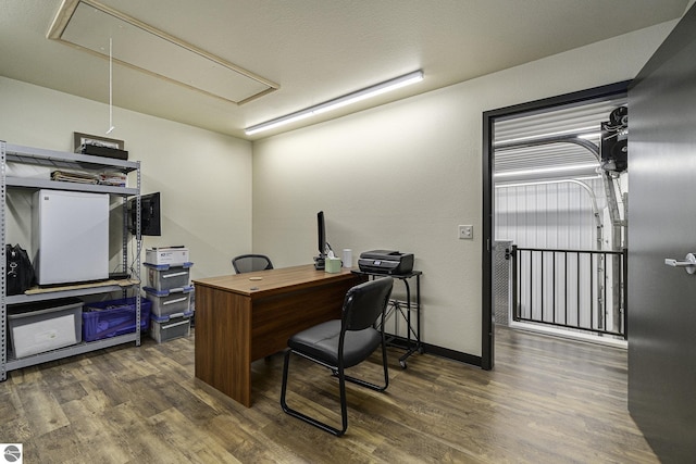 office with attic access, baseboards, and wood finished floors