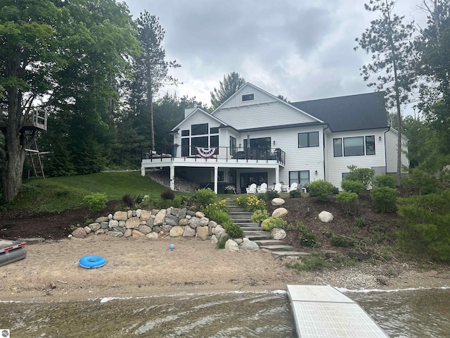 back of property featuring a deck and stairs