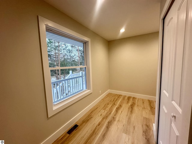 empty room featuring visible vents, light wood finished floors, and baseboards