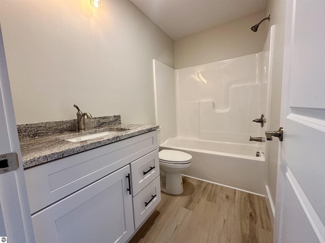 full bath featuring toilet,  shower combination, wood finished floors, and vanity