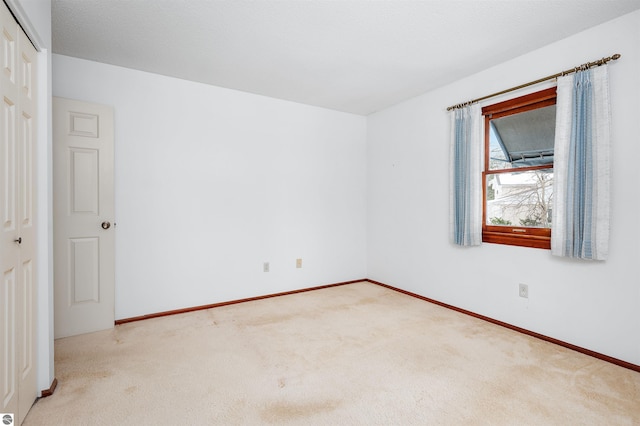 carpeted empty room with baseboards