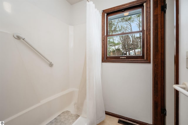 bathroom with a shower with curtain, baseboards, and visible vents