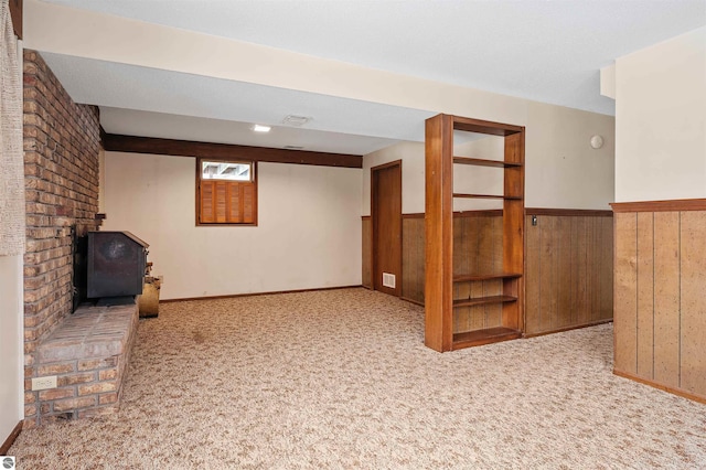 basement featuring carpet floors, wainscoting, and wooden walls