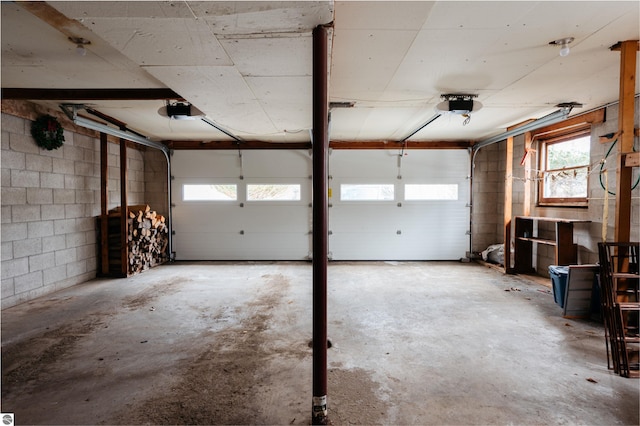 garage with concrete block wall and a garage door opener