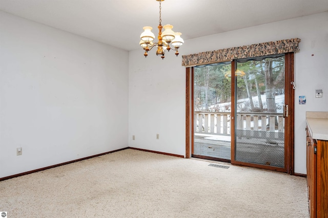 unfurnished room with carpet, visible vents, a notable chandelier, and baseboards