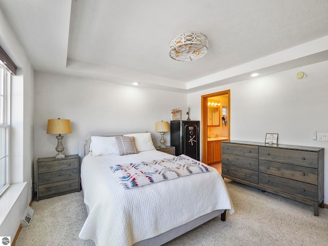 bedroom with a tray ceiling, visible vents, light carpet, and recessed lighting