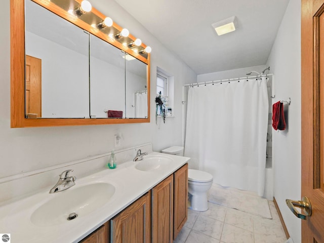 full bathroom featuring toilet, marble finish floor, double vanity, and a sink