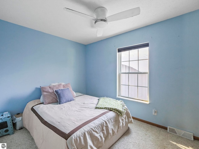 carpeted bedroom with visible vents, ceiling fan, and baseboards